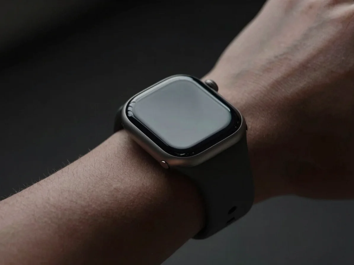 Close-up of a high-end smartwatch on a dark, textured wrist, with
